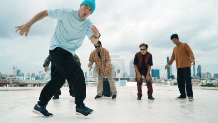Photo for Professional break dance team practice B-boy dance while multicultural friends at rooftop. Young modern dancing group doing hip hop movement. Style,fashion,action. Outdoor sport 2024. Endeavor. - Royalty Free Image