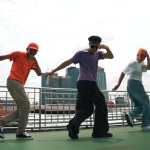 Group of skilled break dancer perform hip hop foot step together at rooftop with city or skyscraper view. Handsome hipster team moving to funky music at public place. Outdoor sport 2024. Sprightly.