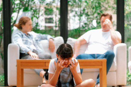 Photo for Stressed and unhappy young girl crying and trapped in middle of tension by her parent argument in living room. Unhealthy domestic lifestyle and traumatic childhood develop to depression. Synchronos - Royalty Free Image