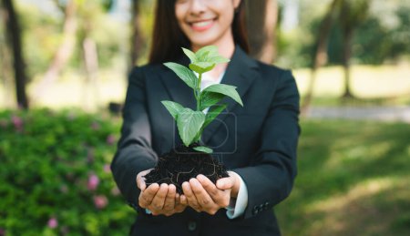 Téléchargez les photos : Femme d'affaires asiatique tenant l'usine comme concept d'éco-entreprise engagée dans la responsabilité sociale des entreprises, la réduction des émissions de CO2, la protection de l'environnement et l'adoption du principe ESG pour un avenir durable. - en image libre de droit
