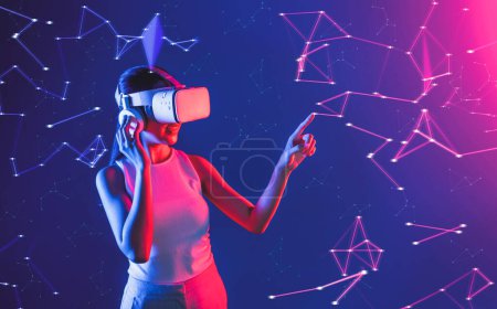 Photo for Female standing in cyberpunk neon light wear white VR headset and tank top connecting metaverse, future cyberspace community technology, She using finger touch virtual reality object. Hallucination. - Royalty Free Image