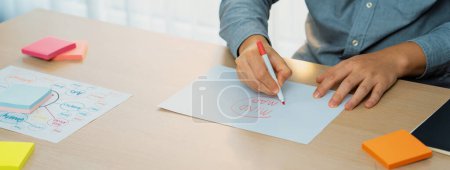 Photo for Skilled businessman brainstorms marketing ideas using mind maps. Successful male startup leader drafts financial plan on table with sticky notes scatter around. Closeup. Focus on hand.Variegated. - Royalty Free Image