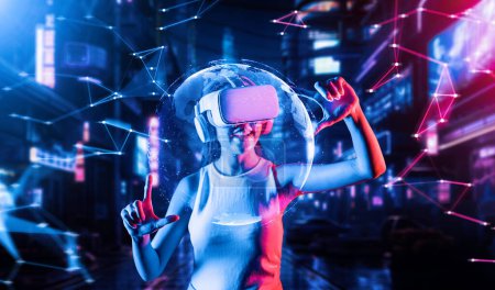 Photo for Female stand in cyberpunk style building in meta wear VR headset connecting metaverse, future cyberspace community technology, Woman use thumb and index fingers focus 3d hologram globe. Hallucination. - Royalty Free Image