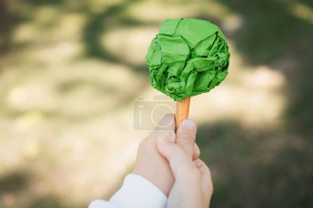 Photo for Little boy holding recycled paper tree to promote eco lifestyle on reducing, reusing, and natural reforestation and long-term environmental sustainability for future generation. Gyre - Royalty Free Image