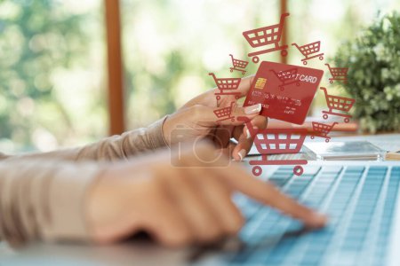 Photo for Elegant customer wearing brown sweater holding credit card typing laptop choosing online platform. Smart consumer opening e-commerce application use cashless technology shopping inventory. Cybercash. - Royalty Free Image