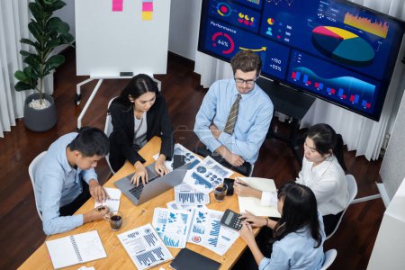 Photo for Wide top view of diverse group of business analyst team analyzing financial data report paper on meeting table. Chart and graph dashboard by business intelligence analysis. Meticulous - Royalty Free Image