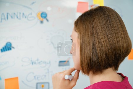 Portrait of young beautiful caucasian businesswoman thinking creative marketing strategy idea in front of whiteboard with mind map and colorful sticky notes. Arm chin. Closeup. Immaculate.