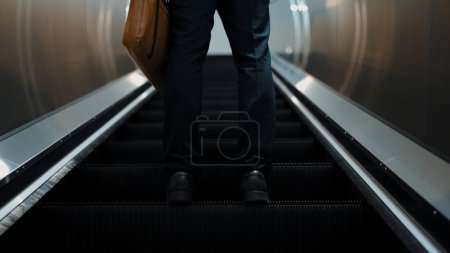 Photo for Cropped image of professional business man standing at escalators. Closeup of skilled project manager getting promotion, increasing skill, upgrading, getting new position. Center. Exultant. - Royalty Free Image