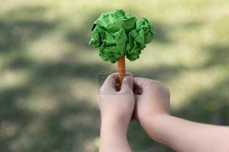 Photo for Little boy holding recycled paper tree to promote eco lifestyle on reducing, reusing, and natural reforestation and long-term environmental sustainability for future generation. Gyre - Royalty Free Image