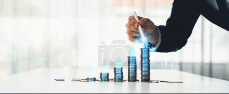 Photo for Coin stack with digital graphic indicator symbolizing business investment and economic growth. Businessman doing financial planning to achieve financial goal and contribute to profit. Shrewd - Royalty Free Image