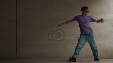Photo for Skilled smart street dancer practice b-boy movement in building with gray background. Young handsome attractive choreographer perform energetic and active movement. Outdoor sport 2024. Sprightly. - Royalty Free Image