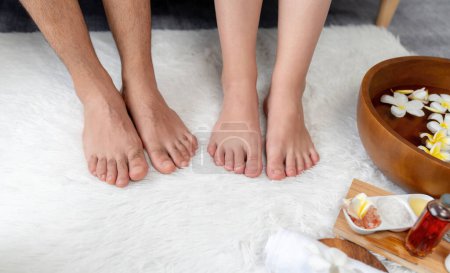 Paar gönnt sich eine glückselige Fußmassage im luxuriösen Wellness-Salon zur Reflexzonentherapie in sanftem Tageslicht-Ambiente Resort oder Hotel-Fußbad. Ruhige Lage