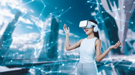 Photo for Female stand wear white VR headset and white sleeveless connect metaverse, future technology create cyberspace community. She look around and gesticulate enjoy fantasy building in meta. Hallucination. - Royalty Free Image