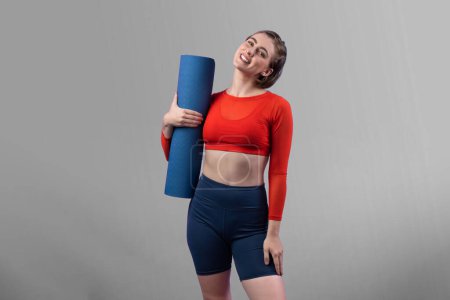 Photo for Full body length gaiety shot athletic and sporty young woman with fitness matt in exercise posture on isolated background. Healthy active and body care lifestyle. - Royalty Free Image