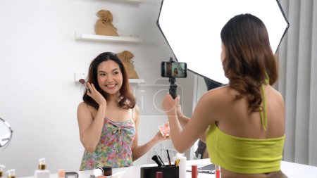 Photo for Two influencer partner shoot live streaming vlog video review makeup social media or blog. Happy young girl with vivancy cosmetics studio lighting for marketing recording session broadcasting online. - Royalty Free Image