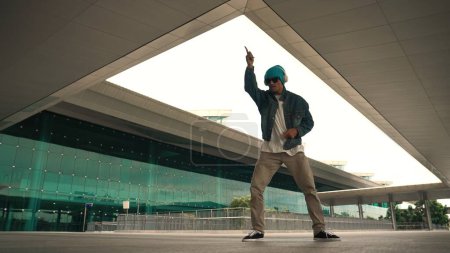 Photo for Motion shot of happy hipster practice b boy dance with stylish cloth at building. Dancer enjoy show footstep performance. Modern lifestyle, break dancing. Slow motion. Outdoor sport 2024. Sprightly. - Royalty Free Image