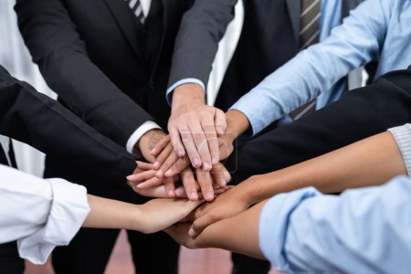 Téléchargez les photos : Les gens d'affaires multiraciaux font synergie main pile ensemble dans la salle de réunion comme coopération ou team building pour les employés de l'entreprise sur le lieu de travail. Méticuleux - en image libre de droit