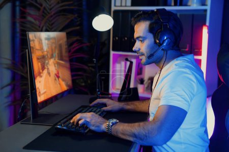 Smart gaming streamer enjoy playing battle team with streaming online shooting gun game with multi or single player at warship on pc screen, wearing headset at digital neon light cyber room. Surmise.