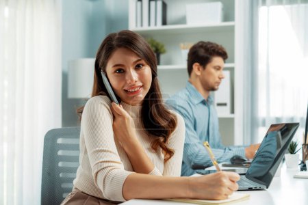 Photo for Smiling beautiful woman using phone call with searching customer list, looking at camera photo shooting portrait business pose profile with smart coworker at modern office at morning time. Postulate. - Royalty Free Image