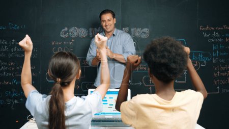 Photo for Teacher turn around and clapping hands to celebrate successful project while student raised arms with happiness. Instructor applause highschool children to inspire to coding program. Edification. - Royalty Free Image