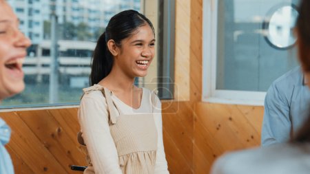 Photo for Young student smiling while listening other student in meeting or group discussion. Cute teenager talking about her experience and sharing to friends in mixed races. Creative education. Edification. - Royalty Free Image