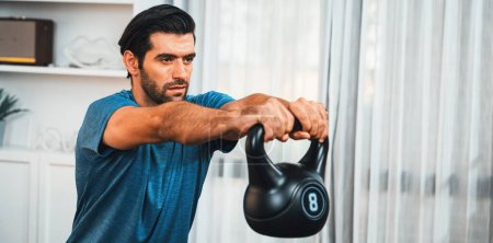 Athletischer Körper und aktiver, sportlicher Mann beim Kniebeugen mit Kettlebell-Gewicht zur effektiven gezielten Muskelzunahme zu Hause als Konzept eines gesunden, fitten Körpers Home Workout-Lebensstils.