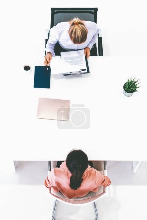 Foto de Dos mujeres de negocios jóvenes en reunión en la mesa de la oficina para la aplicación de empleo y el acuerdo de negocios. Concepto de reclutamiento y recursos humanos. BARROS - Imagen libre de derechos