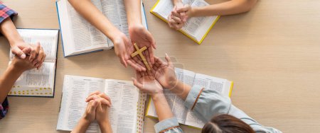 Photo for Close-up women prayer deliver holy bible book and holy cross to believer group. Spreading religion symbol. Concept of hope, religion, christianity and god blessing. Warm background. Burgeoning. - Royalty Free Image