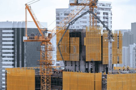 Photo for Image of exterior skyscrapers construction site with tower cranes. Cityscape under construction with cranes working moving to renovate building. Blue sky background. Architectural. Ornamented. - Royalty Free Image