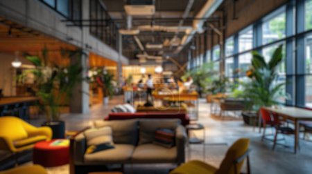 Defocused image of a lively modern co-working area with people and indoor plants. Resplendent.