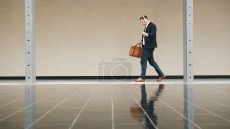 Photo for Side view of business people wear his headphone and walking to workplace along the street in urban city. Professional project manager going to meeting while listen relaxing music from headset. Urbane. - Royalty Free Image