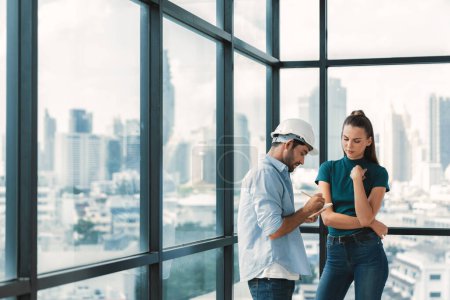 Photo for Professional smart architect engineer team discuss and solve building construction problems. Engineer taking a note while listening manager sharing idea about work surrounded by skyscraper. Tracery. - Royalty Free Image