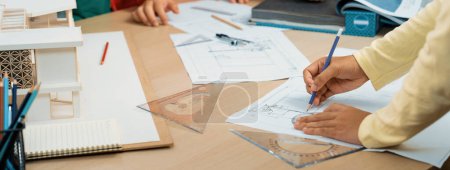 Photo for Cropped imaged of professional architect team discuss about interior material during project manager choose curtain material with house model and architectural equipment scatter around. Variegated. - Royalty Free Image