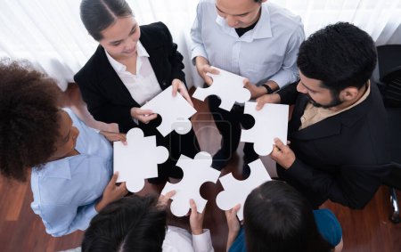 Téléchargez les photos : Divers employés d'entreprise collaborent au bureau, reliant des pièces de puzzle pour représenter le partenariat et le travail d'équipe. Unité et synergie dans le concept d'entreprise en fusionnant puzzle. Concord - en image libre de droit