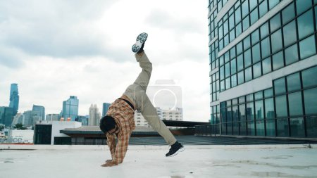 Happy hispanic dancer wears casual outfit break dancing at urban city. Energetic hip-hop performance. Choreographer move along the freestyle beat. Hip hop dancing. Outdoor sport 2024. Endeavor.