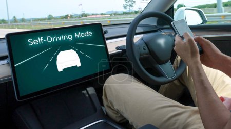 Photo for Self driving car or autonomous vehicle travel on speed highway with driverless system and autopilot mode allowing man driver relax and focus on smartphone without compromising safety. Perpetual - Royalty Free Image