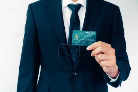 Foto de Retrato del hombre de negocios sosteniendo una tarjeta de crédito que muestra la vista frontal a la cámara en vista cercana. Negocios de compras en línea y concepto de pago sin efectivo. BARROS - Imagen libre de derechos