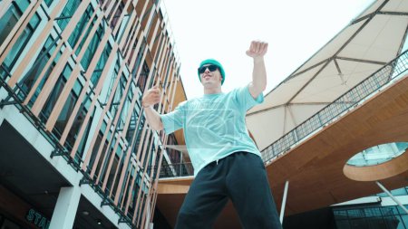 Photo for Portrait of caucasian street dancer looking at camera. Young attractive man moving, dancing practicing hip hop performance at modern mall. Low angle. Freestyle dance. Outdoor sport 2024. Endeavor. - Royalty Free Image