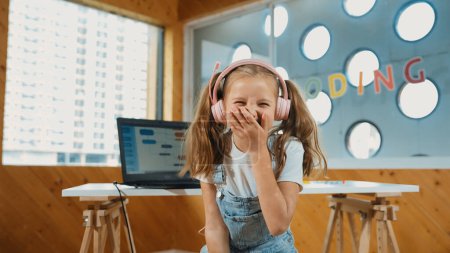 Photo for Little pretty caucasian girl smiling to camera while laughing in funny mood. Young child wearing headphone and casual dress standing while looking at camera with satisfy, happy, joyful. Erudition. - Royalty Free Image