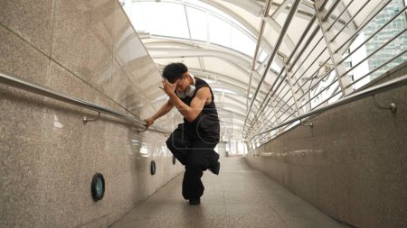 Photo for Motion shot of skilled handsome hipster perform street dancing at narrow corridor. Professional hip hop dancer show b-boy step at corridor while wearing stylish cloth. Outdoor sport 2024. Sprightly. - Royalty Free Image