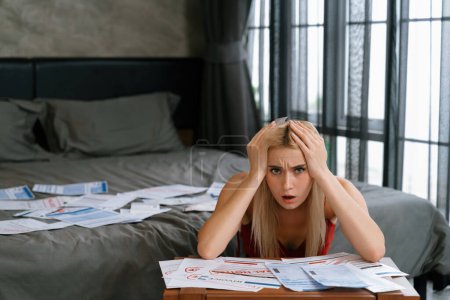 Photo for Stress worried young woman sit at table, as she pay bills online with credit card from financial debt problem, monthly expense and credit card debt. Over spending money lifestyle problem. Blithe - Royalty Free Image