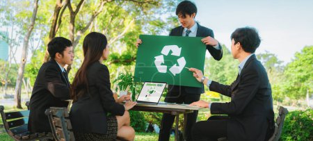 Gruppe von Geschäftsleuten trifft sich im Outdoor-Büro in der Natur Planung und Brainstorming über Recycling-Strategie für eine grünere Umwelt durch Verringerung und Wiederverwendung von recycelbaren Abfällen. Kreisel