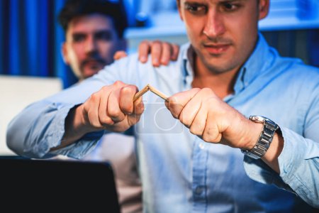 Photo for Stressful burnout of businessman destroying pencil for venting emotion in overwork load at night time, supported by business partner to solve issue problem at neon light of workplace. Sellable. - Royalty Free Image