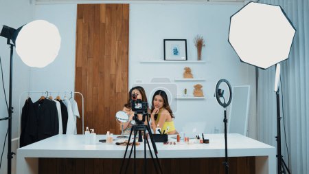 Photo for Two influencer partner shoot live streaming vlog video review makeup social media or blog. Happy young girl with vivancy cosmetics studio lighting for marketing recording session broadcasting online. - Royalty Free Image