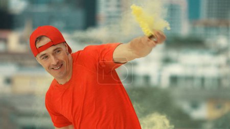 Photo for Portrait of skilled caucasian hipster hold yellow smoke flare on roof top at building. Group of break dance practicing performance with sky scrapper Blurring background. Outdoor sport 2024. Endeavor. - Royalty Free Image