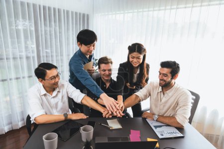 Un groupe d'employés de bureau divers s'unissent dans la salle de bureau pour symboliser la synergie des affaires et un travail d'équipe productif solide sur le lieu de travail. Coopération et unité entre les employés de l'entreprise. Prudent