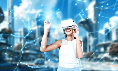 Foto de El soporte femenino lleva auriculares VR blancos y el blanco sin mangas conectan la metáfora, la tecnología futura crea una comunidad del ciberespacio. Usa el dedo índice para tocar el holograma objeto de la realidad virtual. Alucinaciones. - Imagen libre de derechos