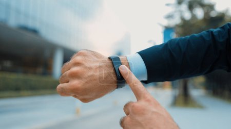 Photo for Closeup of professional businessman hand show smart watch and pointing the times. Professional boss, ceo, leader checking time from top view with city view. Business. Blurred background. Exultant. - Royalty Free Image