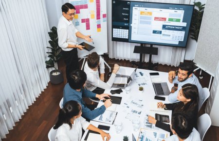 Photo for Project manager communicate and collaborate with team using project management software display on monitor, tracking progress of project task and making schedule plan at meeting table. Prudent - Royalty Free Image