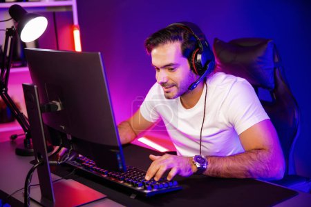 Photo for Smart gaming streamer talking with team member players using headset and mic for communicate with others on streaming live on social media application at digital neon lighting studio room. Surmise. - Royalty Free Image